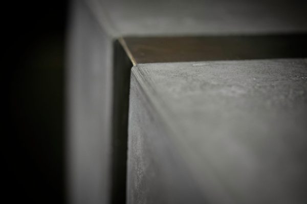 Close-up of polished concrete reception desk brass inlay detail