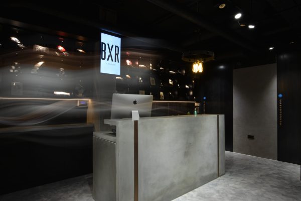 Polished concrete reception desk with dark timber interior at BXR
