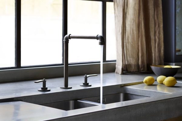 Polished concrete worktop with blackened bronze kitchen tap at The Ponds, Goostrey