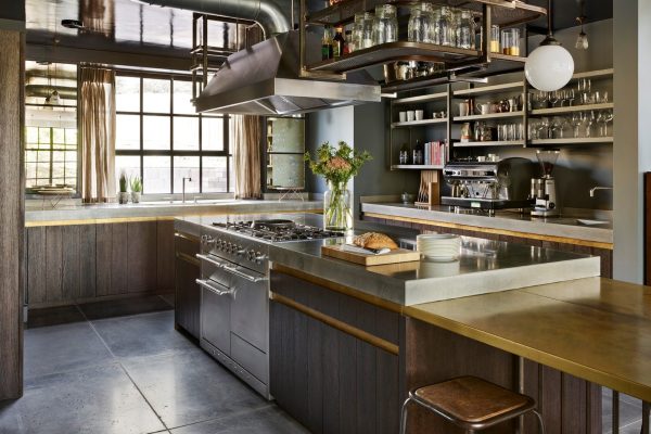 Industrial kitchen with polished concrete island and exposed steel ductwork