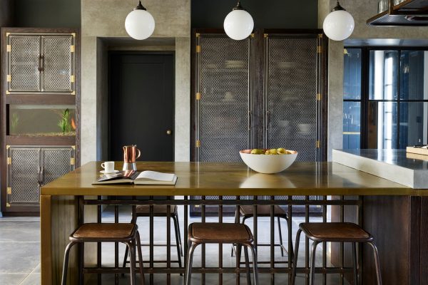 Polished concrete worktop with dark oak cabinetry and brass island