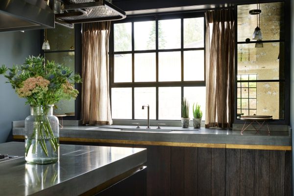 Polished concrete worktops beneath industrial kitchen shelving and steel ducting