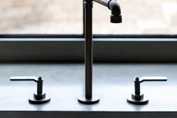 Polished concrete worktop and black kitchen tap at The Ponds, Cheshire