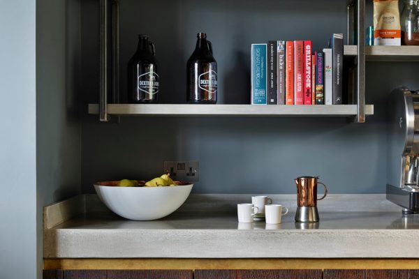 concrete worktop with open steel shelving and brass shadow trim detail